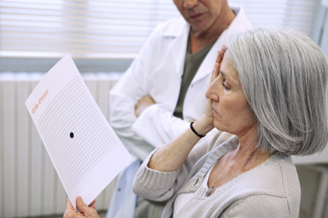 Older woman being screened for macular degeneration with an Amsler Grid